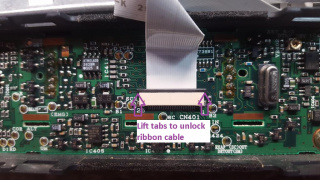 320px]  9) With the tabs up, pull the ribbon out of the connector on the back of the faceplate circuit board.     10) Remove the 4 screws holding the faceplate circuit board to the faceplate.     11) With the screws removed, flip the faceplate over putting the circuit board down and display and buttons up.  The faceplate circuit board may begin to slide backwards, apply gentle pressure to the buttons to help free the circuit board if needed.    12) On the TK-n62(H) radios only, there will be a foam insert that sits between the faceplate and faceplate circuit board.  This can be brittle so carefully lift it off the board.    13) Pull away the rubber membrane that makes up the buttons and set it off to the side    14) Flipping the solder side of the front faceplate circuit board forward, examine the noted points for connection.  The COR, Discriminator and Microphone Input lines all have convenient solder pads for connections.  The PTT must be soldered to the pin on the rear of the RJ-6 connector.  The Modulator input is soldered to the left side of the capacitor near the microphone connector.  On some newer models, there may be a small solder pad just below the Modulator Input capacitor for a convenient solder pad.    15) Cut about 8" of 6 conductor ribbon cable, multicolor is suggested.  In this build the following colors are used:  Brown = COR Black = Discriminator Audio White = Ground Grey = Modulator Input Purple = PTT Blue = Microphone Input  16) Separate the COR and Discriminator audio lines from the ribbon cable.  Strip and tin about 1/8" on the COR cable.    17) Apply a small amount of solder to the COR, Discriminator and Microphone Input pads      When finished they should look like this:      18) Solder the COR wire to the COR solder pad    19) Separate the discriminator audio wire and cut it to length to be soldered on the discriminator audio pad.     20) Strip about 1/8" and tin the discriminator audio wire    21) Solder the discriminator audio wire to the solder pad    22) Separating the remaining ribbon cable, fold the wires as shown to run the ground wire (white) along the grounding pad on the rear of the microphone conenctor    23) Cut the ground wire to length so it can be soldered to the large grounding pad    24) Strip and tin about 3/16" of the ground wire    25) Solder the ground wire to the grounding pad    26) Apply more solder to the modulator input capacitor.  If the radio has a solder pad below the capacitor, apply more solder to that pad instead.     27) Feeding the remainder of the ribbon cable through, line up the modulator input wire next to the modulator input capacitor or solder pad, cutting to length.    28) After cutting the modulator wire, strip and tin about 1/8" from the wire    29) Solder the modulator wire to the capactitor or solder pad if present.    30) Apply solder to the PTT pin on the back of the faceplate circuit board.  It will be the top row, center pin     31) Line up the remainder of the ribbon cable, cut the PTT wire to length    32) With the PTT wire cut to length, strip about 1/8" and tin    33) Solder the PTT wire to the PTT pin.  Be careful to not create a solder bridge to the adjacent SB or Microphone input pins    34) Line up the last wire in the ribbon cable with the Microphone input pad and cut to length.    35) With the Microphone input wire cut to length, strip about 1/8" and tin    36) Solder the Microphone input wire to the Microphone solder pad    37) Double check all soldered points, left to right it should be COR (Brown), Discriminator Audio (Black), Modulator Input (Gray), Ground (White), PTT (Blue) and Microphone Input (Purple)    38) On the TK-n62(H) radios only, reinsert the foam pad into the faceplate.  Note that one side has a small tab in the center which should be pointed towards the holes for the buttons     39) Take the rubber button membrane and reinsert it into the faceplate     40) Line up the faceplate circuit board, carefully bend the ribbon cable at about a 90 degree angle away from the circuit board.    41) Reinsert the faceplate circuit board into the face, gently pressing downward until fully seated    42) Reattach the screws that hold the faceplate circuit board to the face     43) Slide the faceplate back towards the chassis, lining up the flat ribbon cable with the center connector    44) Reinsert the ribbon cable into the connector and press downward on the brown tabs to lock the ribbon in place     45) Moving back to the chassis, loosen the marked screws.  These do not need to be removed, but should be loosened several turns.     46) Flipping the radio on it's side, apply pressure to the main board, pushing it towards the direction of the loosened screws, with that gap opened, slide the 6 conductor ribbon cable through that gap     47) Move the faceplate back towards the chassis of the radio, gently pulling on the ribbon cable into the chassis area to keep it from bundling up next to the faceplate    48) When the faceplate reaches the chassis, carefully press the faceplate over the tabs on the top and bottom of the chassis     49) Gently pull the ribbon cable through the chassis, do not pull hard, only enough to make the ribbon pulled through completely    50) Flip the radio upside down and resecure the 4 screws loosened to feed through the ribbon cable     51) Cut about 34" of Devicenet cable    52) If you opted to make a modulator input, take a 2.54mm header pin and tin 3 consecutive pins.    53) Cut the 2.54mm 3 pin header which has it's pins tinned.    54) Take about 3" of single wire from the ribbon cable, strip about 1/8" and tin the end to be used for the TX input switch (microphone or modulator). In this build this wire is green.     55) Solder the TX input common wire to the center pin of the 3 pin header.    56) Cut about 3/8" of 1/8" heatshrink tubing    57) Separate about 1" of the modulator input and microphone input wires, strip and tin about 3/16"    58) Slide 2 of the 3/8" sections of 1/8" heatshrink tubing over the modulator and microphone input wires    59) Solder the modulator wire to one side of the 3 pin header    60) Solder the microphone wire to the other side of the 3 pin header, slide the 3rd 3/8" section of the 1/8" heatshrink over the center pin    61) Apply heat to the heatshrink using a heat gun, hair dryer or similar method    62) Take a 2.54mm jumper and slide it over 2 of the pins on the 3 pin jumper  In this position transmit audio is sent to the microphone, suitable for 1200-2400 baud packet, VARA FM and most Fldigi modes    In this position transmit audio is sent to the modulator, suitable for 4800-9600 baud packet and VARA FM wide    63) Cut about 1" of 1/4" heatshrink tubing, slide over the jumper to insulate the connection.  Do not apply heat, this provides a friction fit should the jumper position need to be moved in the future.    64) Fold the microphone, modulator wires back against the ribbon, running the output wire parallel to the other wires on the ribbon    65) Cut about 1" of 1/4" heatshrink tubing and slide it over the ribbon cable    66) With the heatshrink slid away from the ribbon cable ends, strip about 3/16" and tin the COR, Discriminator audio, Ground and PTT wires    67) Cut the TX input wire to length, matching the other, strip about 3/18" and tin     68) Cut 5 pieces about 3/8" of 1/8" heatshrink tube    69) Slide each of the 5 pieces over the 5 wires on the ribbon cable    70) Taking the Devicenet cable, cut the outer jacket about 5/8" from the end.    71) Rocking the end of the cable back and forth, break away the outer jacket, exposing the braid shielding    72) Pull away the jacket, exposing the braid, inner foils and 2 pairs of wire    73) Pull the braid back against the cable, locate and cut away any nylon strands inside the cable    74) Separate the two pairs of wire and twist the common bare ground wire    75) Peel away the foil over each pair of wires, it may be needed to cut the foil to begin to unwrap it    76) Separate all 5 wires on the Devicenet cable, strip back about 3/16" and tin all wires     77) Take the black wire from the Devicenet cable and solder it to the PTT (Purple) wire    78) Take the red wire from the Devicenet cable and solder it to the TX audio input (Green) wire    79) Take the bare wire from the Devicenet cable and solder it to the ground (White) wire    80) Take the blue wire from the Devicenet cable and solder it to the discriminator audio (Black) wire    81) If you want the COR signaling to always be present, take the white wire from the Devicenet cable and solder it to the COR (Brown) wire    82) If you want to be able to enable or disable COR signaling via hardware jumper, take a single row of 2.54mm header pins and tin 3 consecutive pins. This is needed if you want to use this radio with a CM108/RA/URI type interface that supports COR signaling on Windows. With the COR connected all the time to that type interface, the COR signal will mute the speaker output whenever a signal is present and have to manually be reenabled.  Take the COR (Brown) wire and feed it back through the 1/4" heatshrink tubing    83) Slide the 1/4" heatshrink towards the end of the ribbon cable, exposing the tip of the COR wire    84) Pull the COR wire through the heatshrink, making it about even in length with the previously assembled TX audio selector jumper    85) Take a 2.54mm header pin and tin 3 consecutive pins.    86) Cut the 2.54mm 3 pin header which has it's pins tinned.    87) Cut 2 pieces about 3/8" long of 1/8" heatshrink tubing    88) Take about 3" of single wire from the ribbon cable, strip about 1/8" and tin the end to be used for the COR enable switch . In this build this wire is orange.    89) Solder the COR enable output wire to the center pin of the 3 pin header    90) Slide one of the 3/8" long 1/8" heatshrink tubing sections over the COR input wire    91) Solder the COR input wire to an outside pin of the 3 pin header, moving up the heatshrink over the soldered point.  Also slide the other piece of heatshrink tubing over the output in and the unused pin on the 3 pin header.    92) Fold the COR enabling header, wires and heatshrink over the bottom cover of the radio to provide a heat shield  [File:TK-n6n_COR_input_over_bottom_cover.jpg